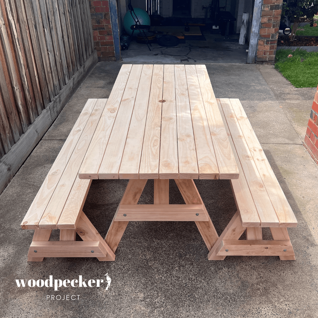 A beautifully crafted picnic table set with a polished wooden surface and detachable benches, suitable for both indoor and outdoor use