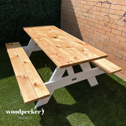 This sturdy wooden picnic table is perfect for outdoor gatherings, providing ample seating space for family and friends to enjoy leisurely meals together in the fresh air.