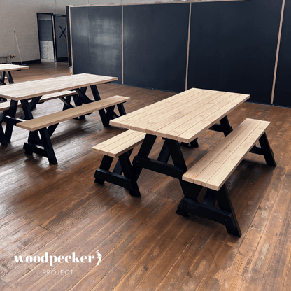 A rustic picnic table set with a weathered wood finish, adding a touch of charm to any garden or outdoor area