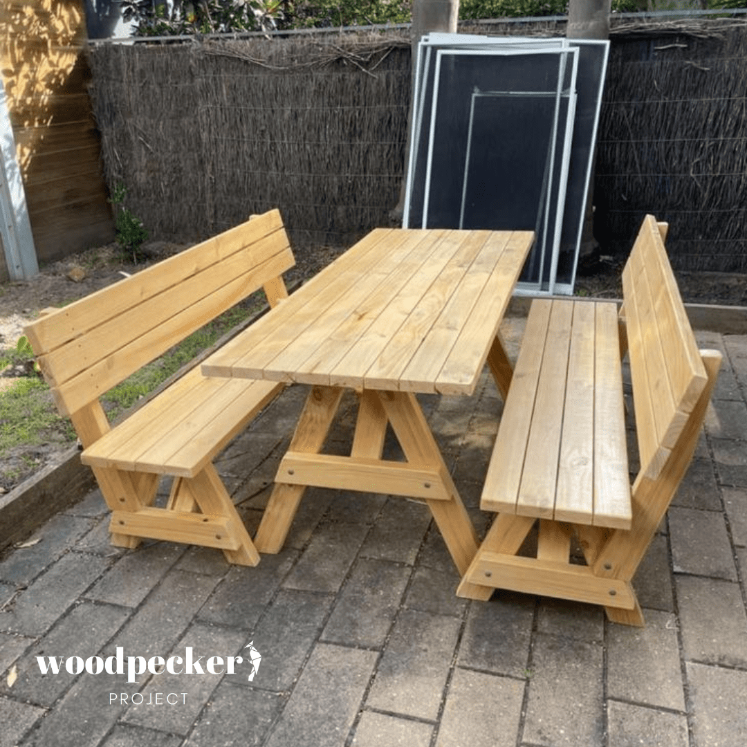 A traditional picnic table set with a natural wood finish and benches with backrests, providing a timeless and comfortable outdoor dining experience