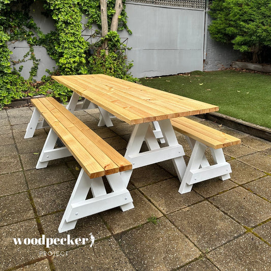 A modern picnic table set with a sleek, minimalist design featuring a sturdy wooden table and two matching benches, perfect for outdoor dining and entertaining