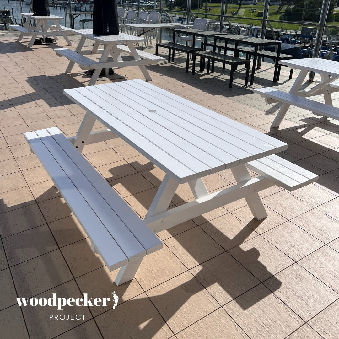 Host your event in style with our contemporary white picnic table, ready for hire, offering a clean and sophisticated aesthetic that complements any decor